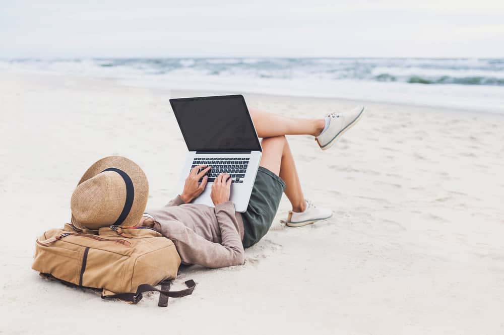 Person on the beach working on a laptop