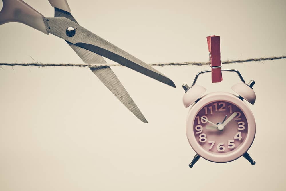 Clock being cut with scissors