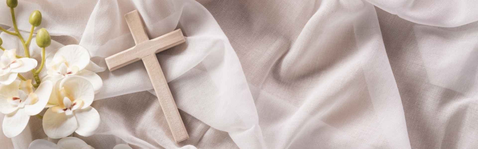 small wooden cross on white fabric