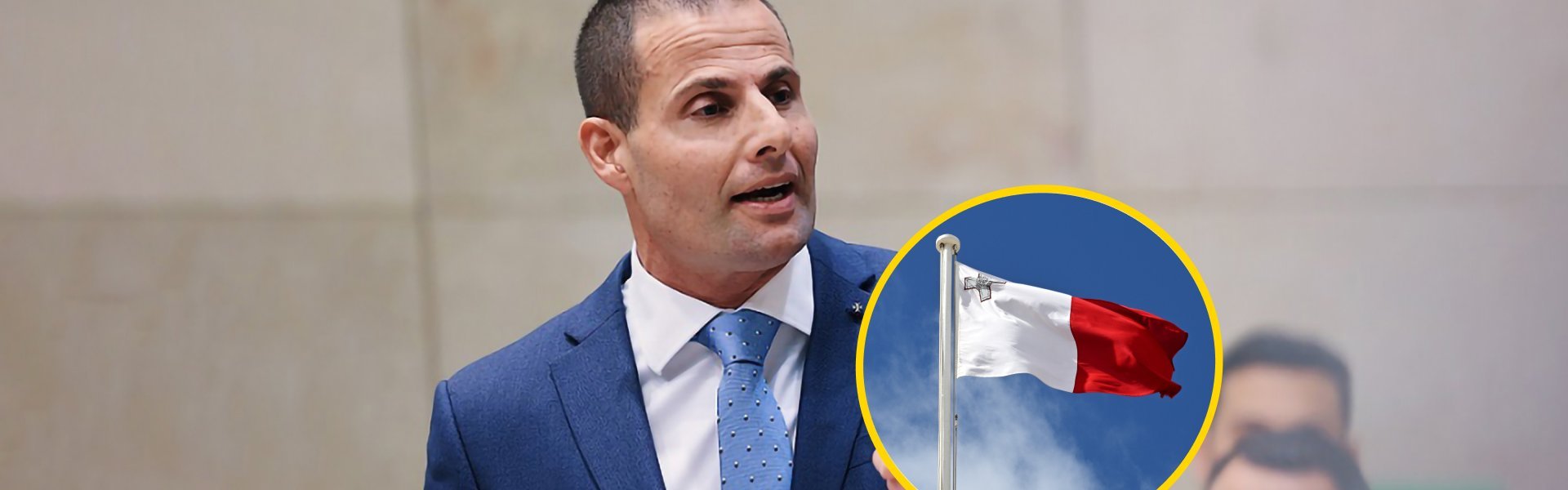 Robert Abela speaking at a formal address in Malta, wearing a navy suit and blue tie, with a circular inset showing the Maltese flag flying against a blue sky.