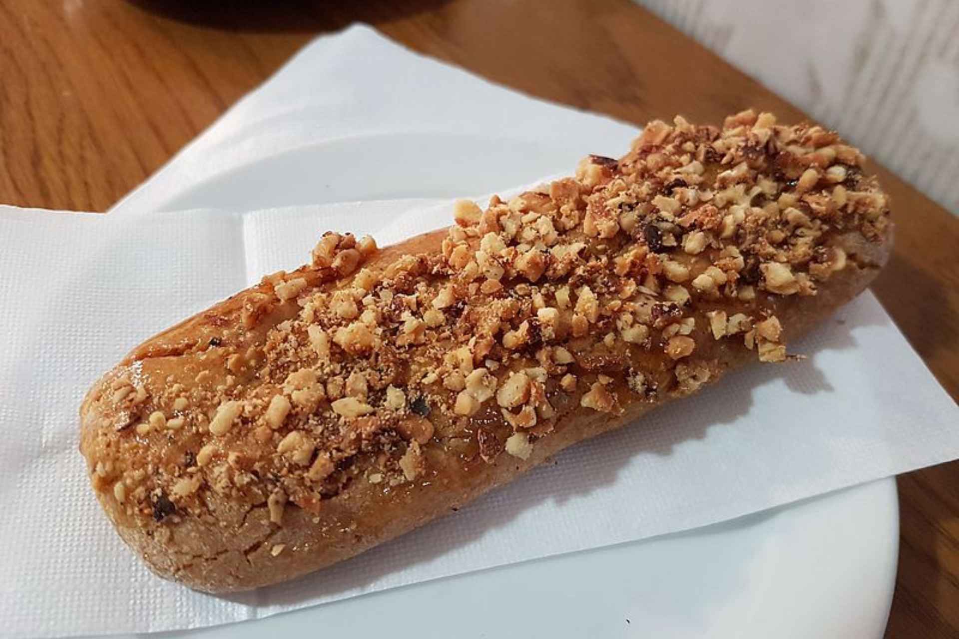 long brown biscuit with almond shavings on top - kwarezimal
